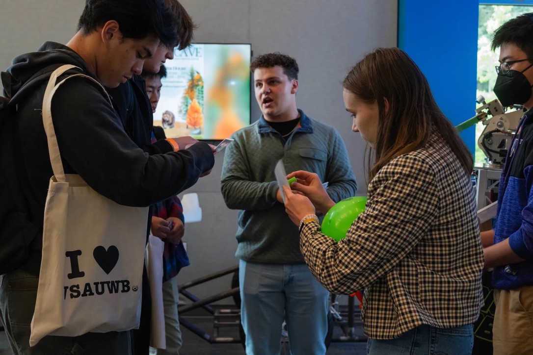 A girl holding a bright green bouncy ball stamps a paper.