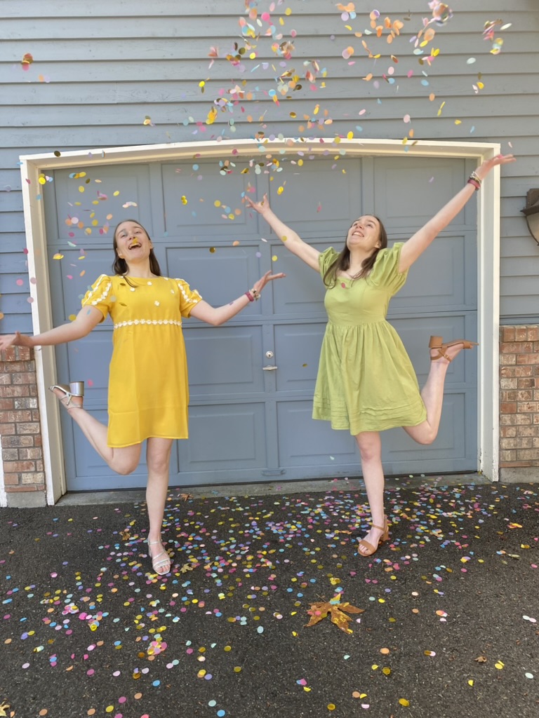 Two girls throwing confetti in the air.