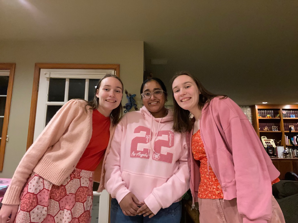 Three girls smiling in pink and red for Galentine's Day.