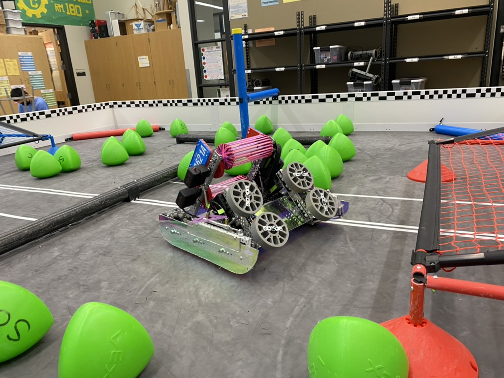 A pink and purple robot in a robot field with green acorn shaped game elements.