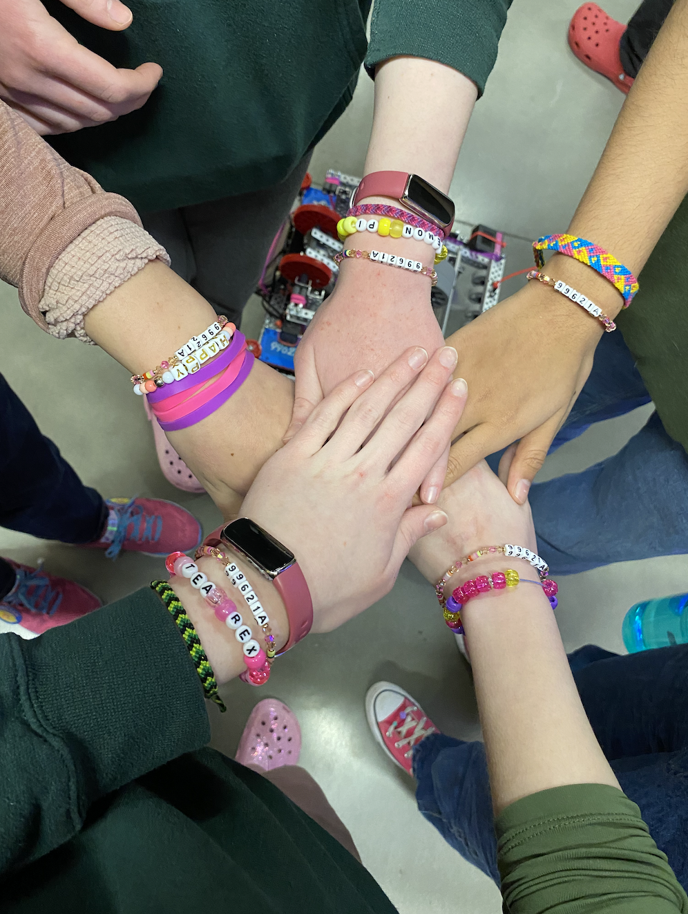 Five hands together. Bracelets up all five wrists.